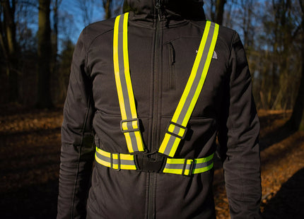 a man wearing a safety vest in the woods